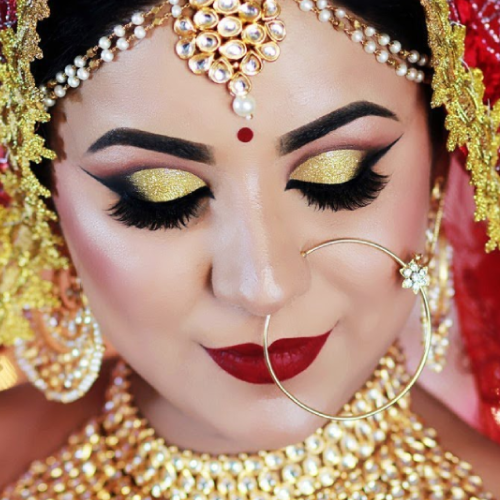 Image of girl Looking like Bride and having golden eye shadow and wearing red color dress